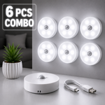 Set of six white motion sensor lights with a control unit and USB cable on a gray surface.