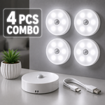 Four motion sensor lights with a control unit and USB cable on a gray surface.